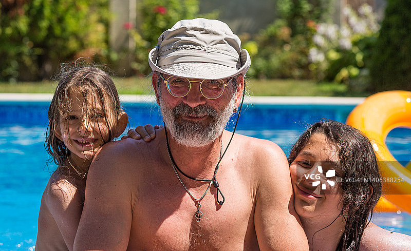 父亲和两个孩子（男孩和女孩）在游泳池里图片素材