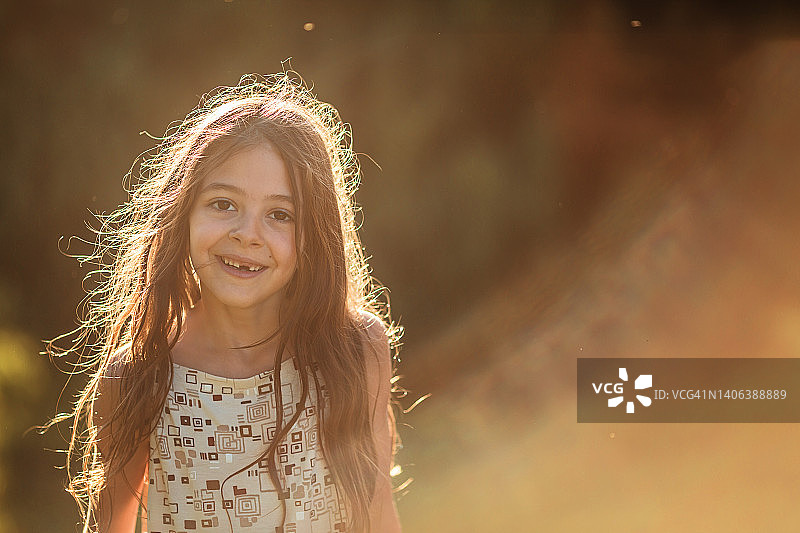 夕阳下，背光拍摄的可爱小女孩图片素材