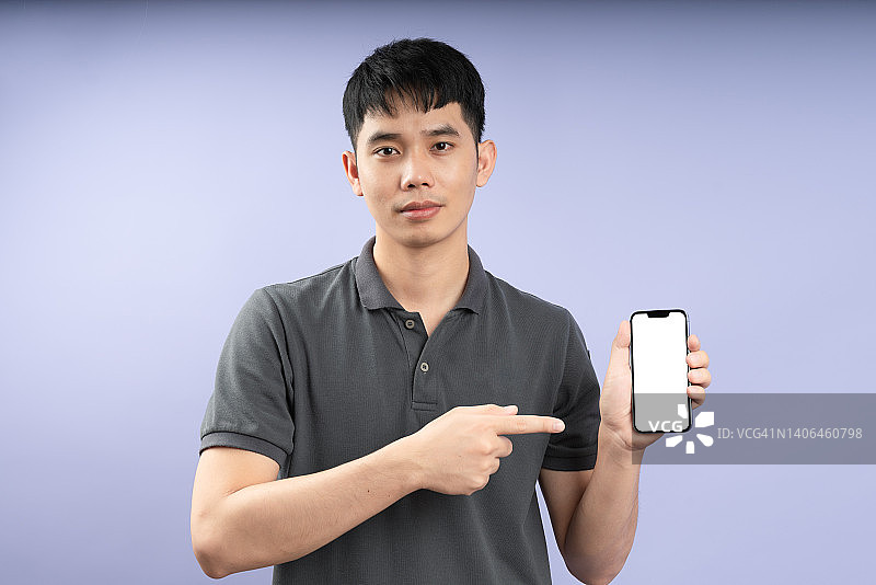英俊男人手持手机，指向文字区域图片素材