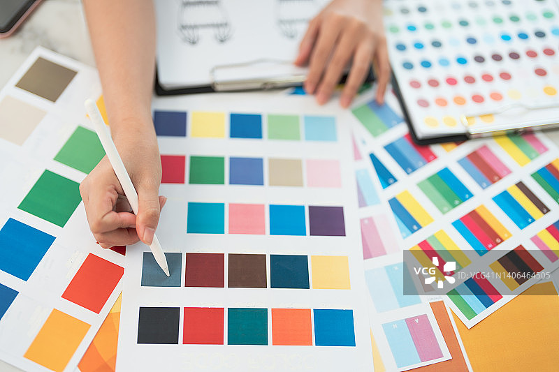 图形设计师工作场景：色板样品，在绘图板上绘画，创意编辑理念图片素材