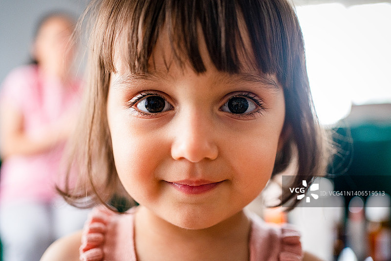 留着齐刘海的可爱小女孩的特写肖像照图片素材