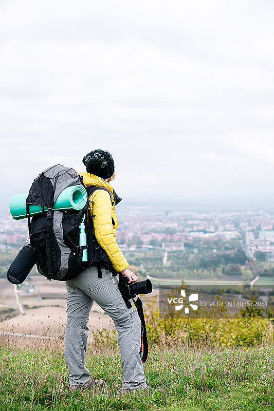 在西班牙维多利亚市，携带背包和相机的游牧女人正在观望图片素材