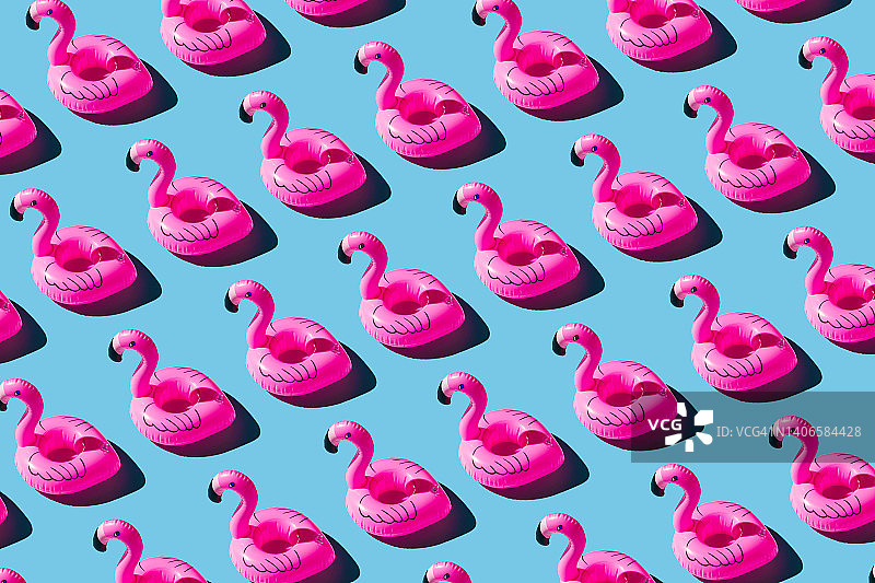 蓝色背景上的粉色充气火烈鸟图案图片素材