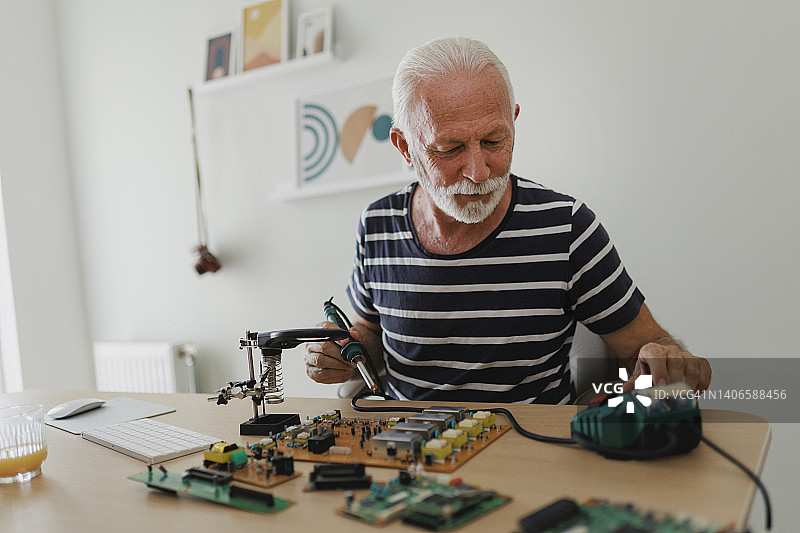 在家研究工程项目的年长男人图片素材