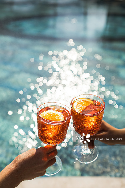 在泳池边用鸡尾酒碰杯庆祝图片素材