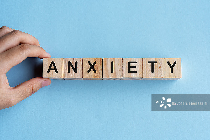 手持木块，文字拼写“焦虑”图片素材