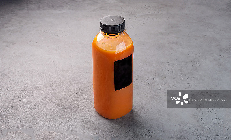 灰色背景下的透明塑料瓶装沙棘果汁图片素材