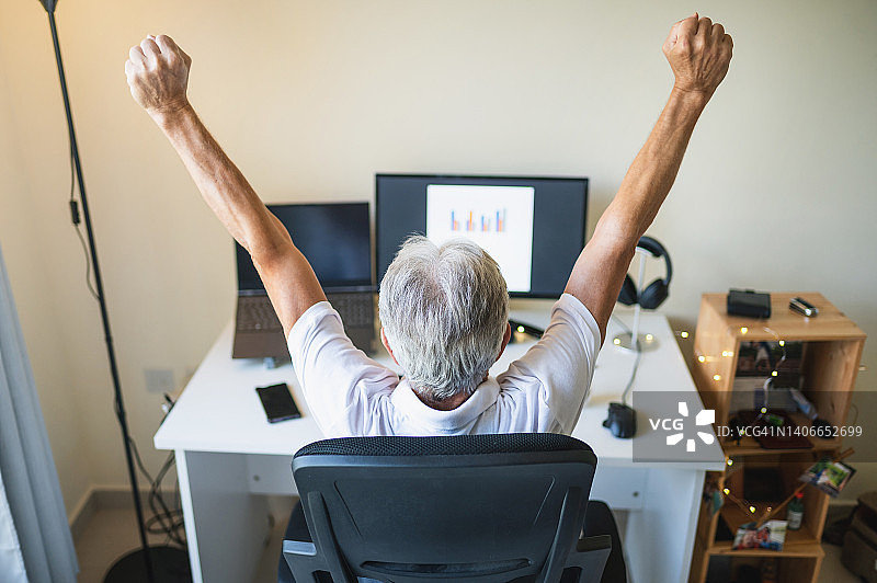 老年男人在家庭办公室远程工作时伸展身体图片素材