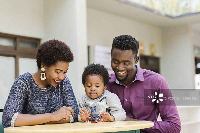 快乐的非洲家庭围坐在户外餐桌旁图片素材