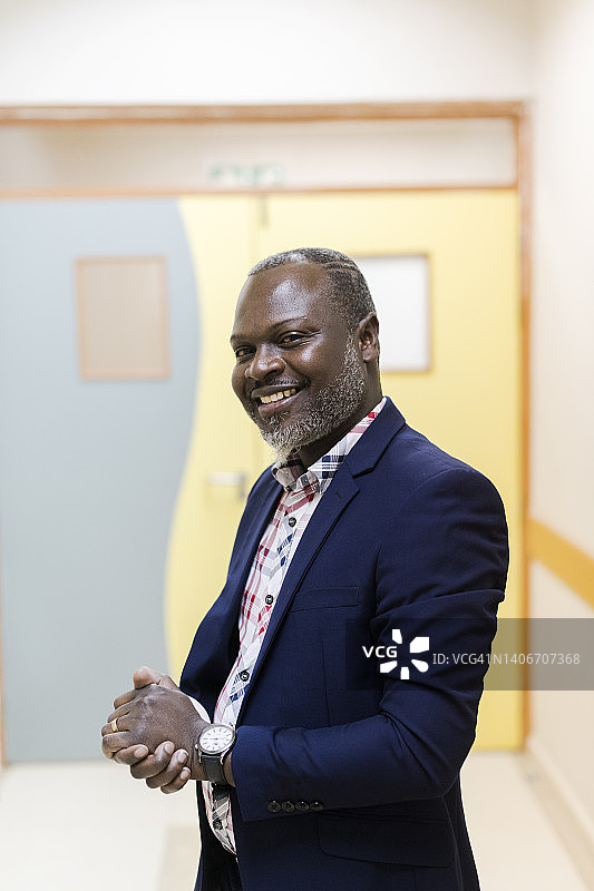 微笑的非洲裔老年男性在医院走廊的肖像图片素材