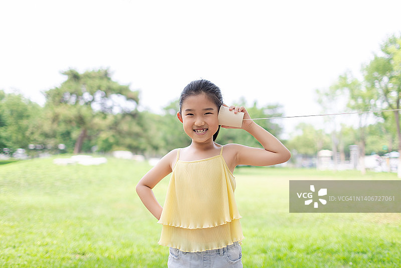 玩着罐头电话的小女孩图片素材