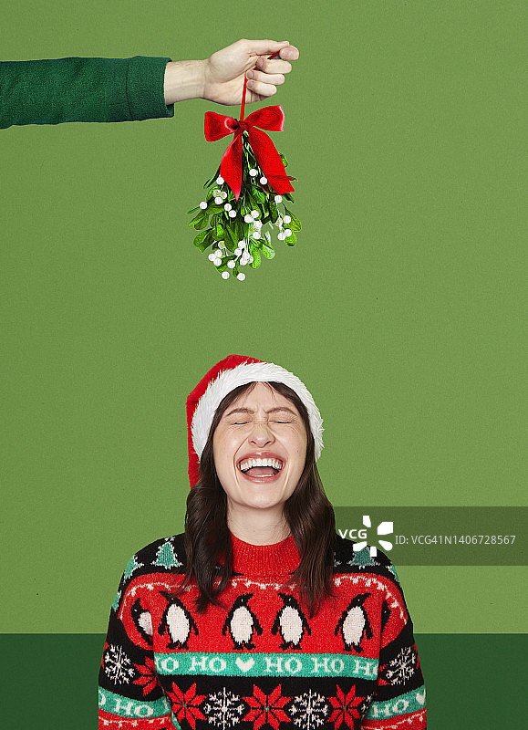 在槲寄生下笑着的女人图片素材