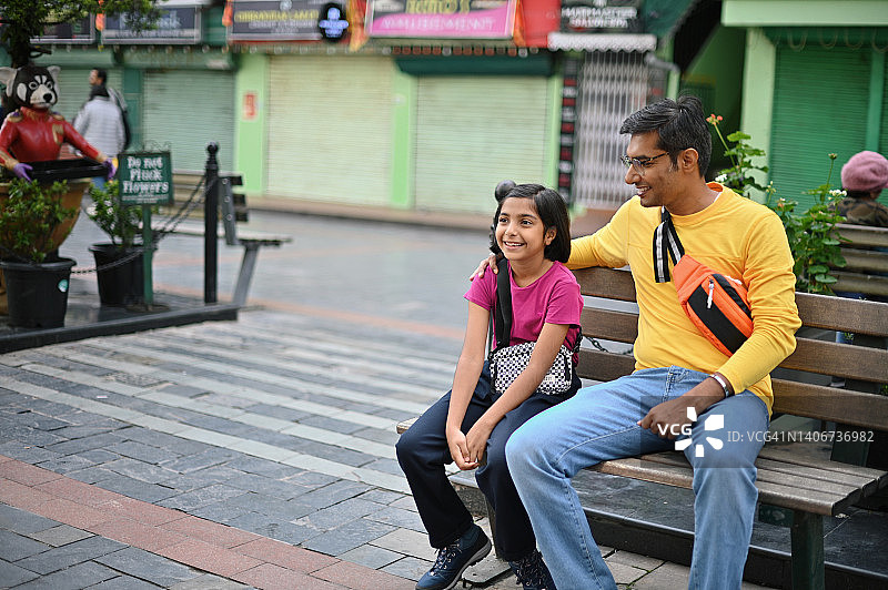 父女坐在长椅上，共度美好时光图片素材