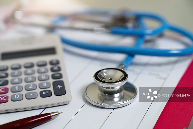 医疗保健成本概念：文件上的听诊器和计算器图片素材