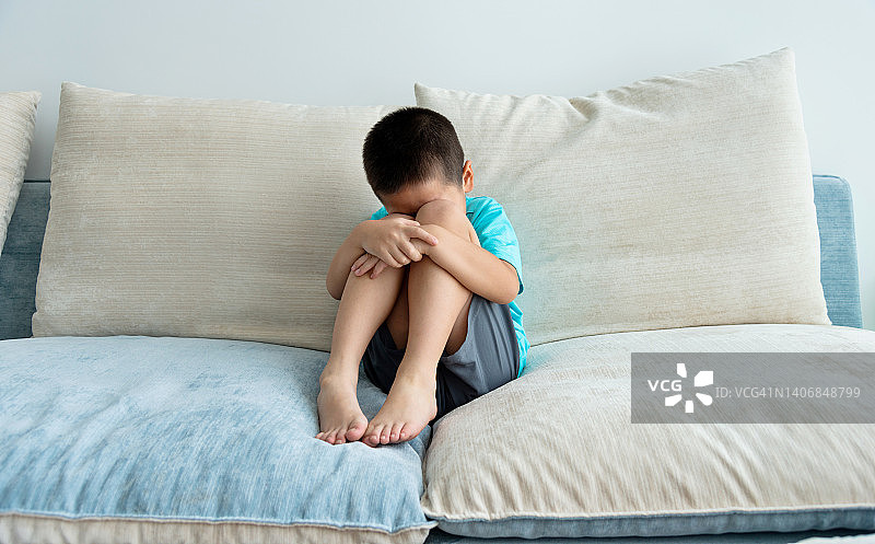 坐在沙发上的悲伤男孩图片素材