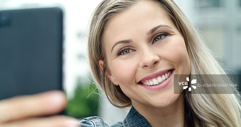 阳光明媚的日子里自拍的快乐年轻女游客肖像图片素材