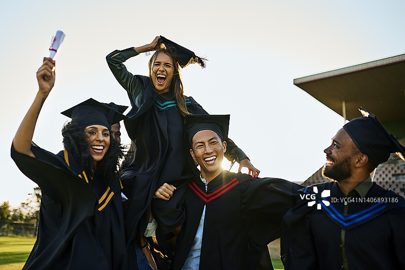 一群毕业生在毕业典礼上欢呼庆祝图片素材