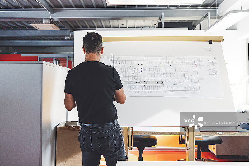 建筑师查看蓝图的背面视角图片素材