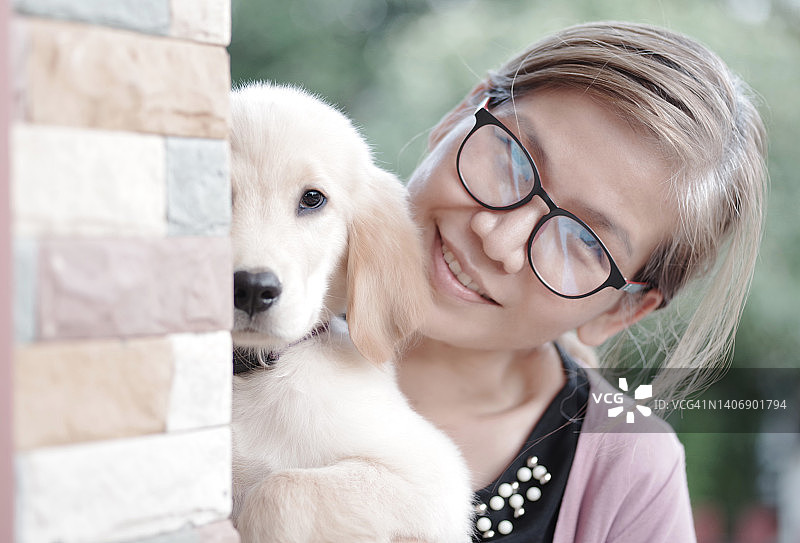 抱着金毛寻回犬幼犬的女子肖像图片素材