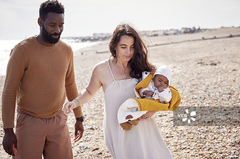 父母带小女儿在海滩散步，享受沿海公路旅行图片素材