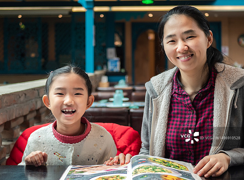 小女孩和母亲在餐厅点餐图片素材