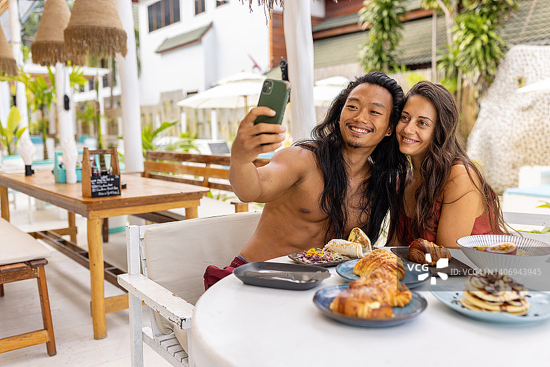 情侣在海滩餐厅享用早餐自拍图片素材