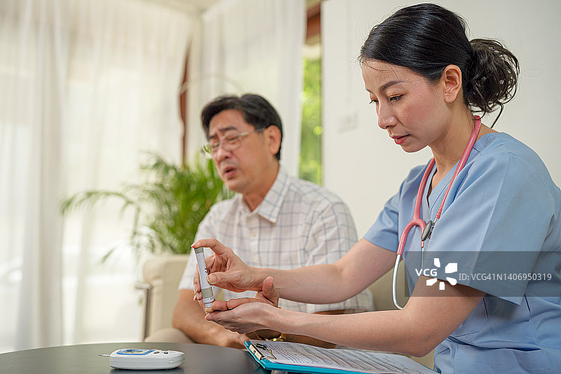 居家医疗保健护士为患糖尿病的中年男子做检查，检查他的血糖水平图片素材