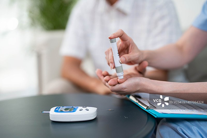 女医生上门为老年患者做血糖检测图片素材