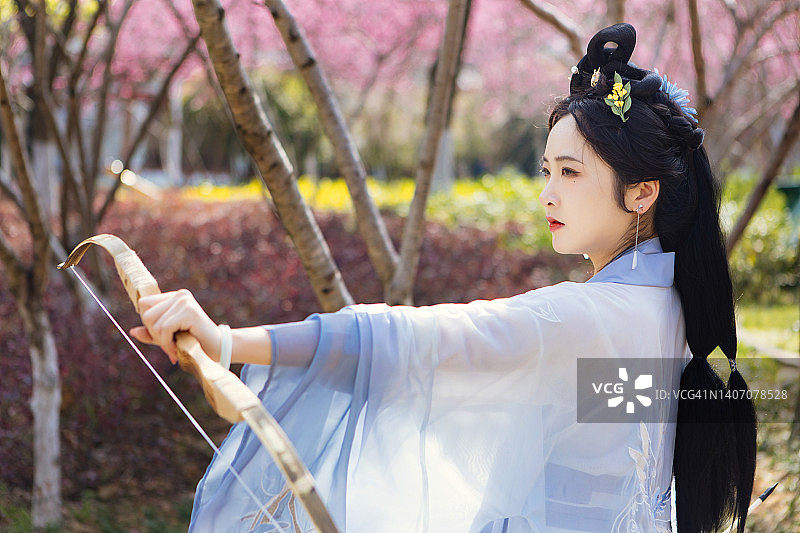 桃花林里的汉服美女射箭图片素材