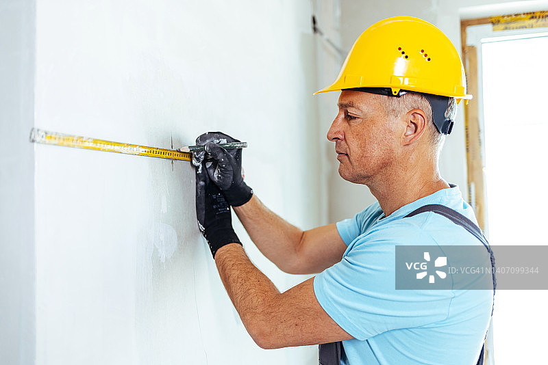 男人正在测量墙壁图片素材