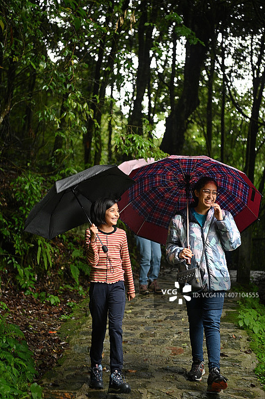 两个女孩在雨中森林徒步旅行图片素材