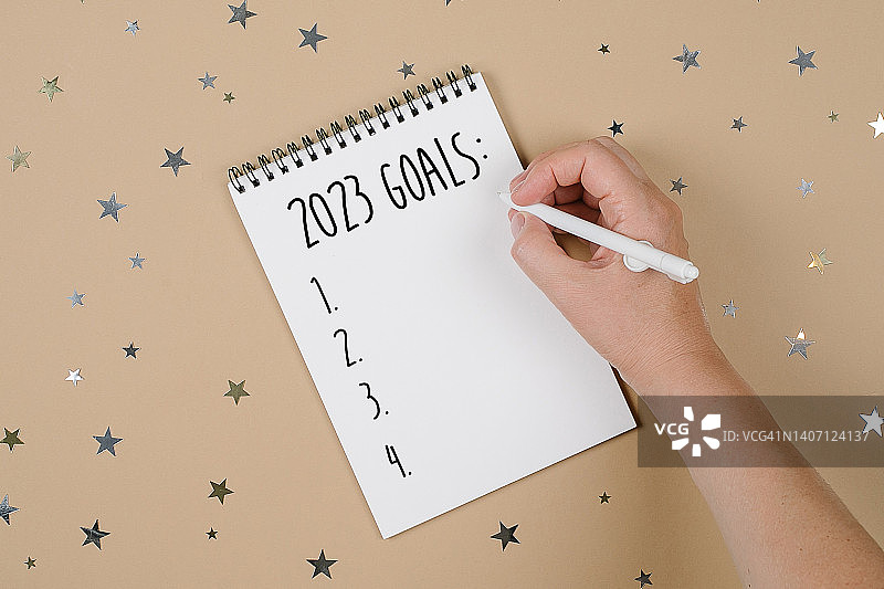 女士在笔记本上写下目标清单，新年计划概念，2023新年目标图片素材