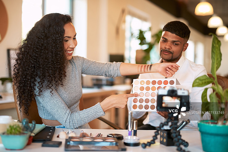 两位化妆师录制美妆视频，在手臂上试色眼影盘图片素材