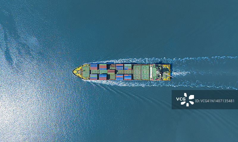 黄色船头的大型集装箱船在海上高速航行：进出口物流国际运输业务图片素材