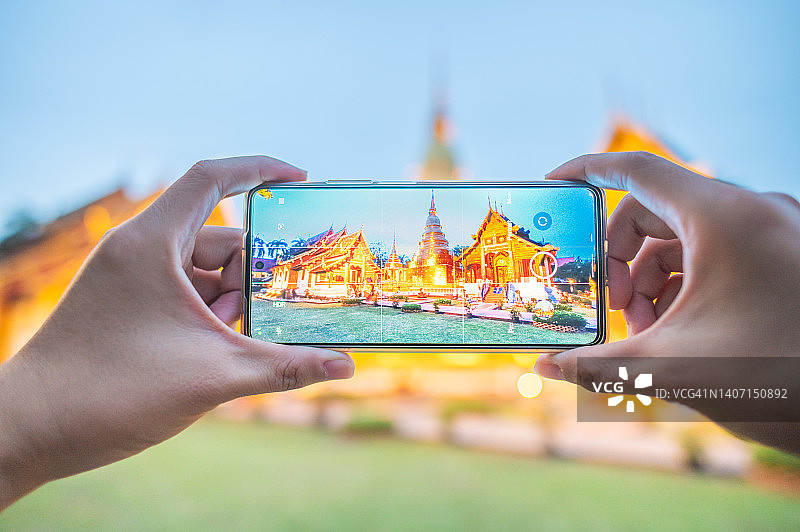 旅行者用手机拍摄清迈帕辛寺美景，背景虚化图片素材