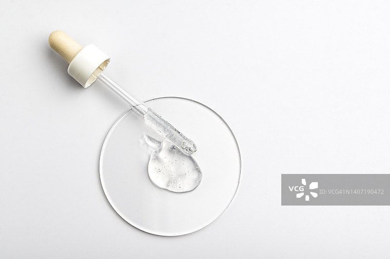 灰色背景上带有凝胶或透明质酸或血清的移液管，移液管中充满了气泡图片素材