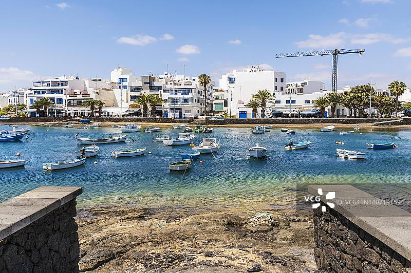 阿雷西费美丽的海滨市中心，许多船只漂浮在蓝色水面上，西班牙加那利群岛兰萨罗特岛图片素材