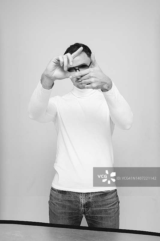 男人用手指模仿相机拍照的姿势-库存照片图片素材