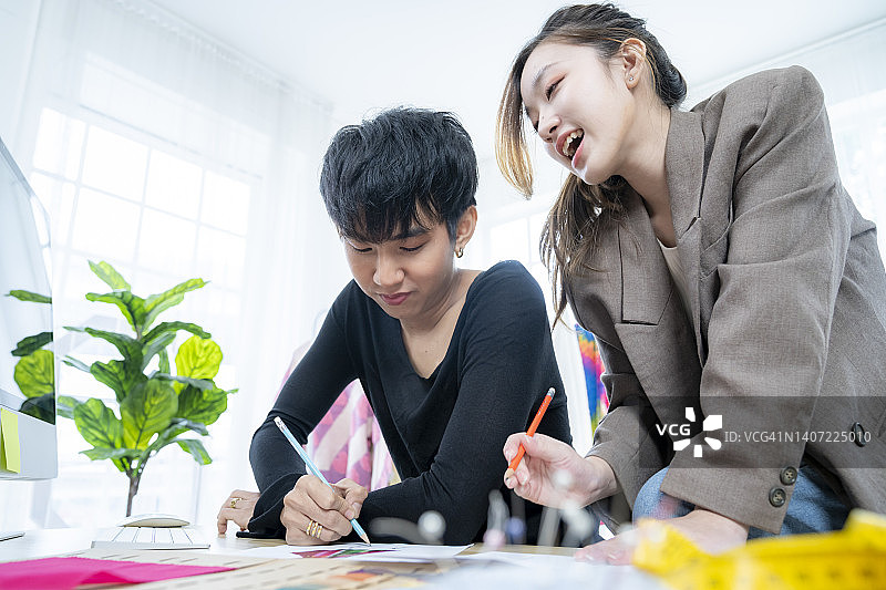 时装设计师在工作室的工作台上绘制草图图片素材