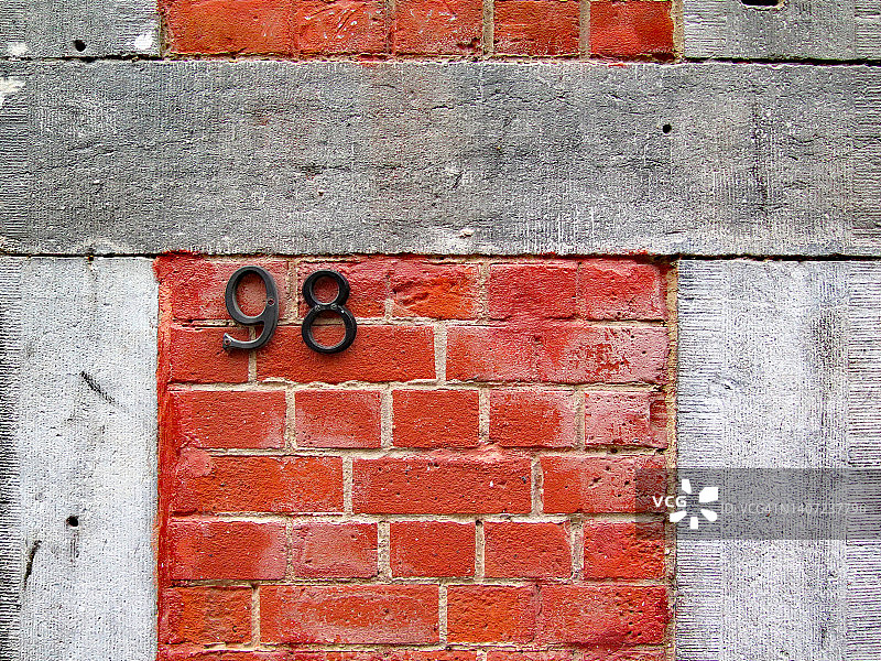 比利时布鲁塞尔房屋的红色砖灰色石头外墙上的数字98图片素材