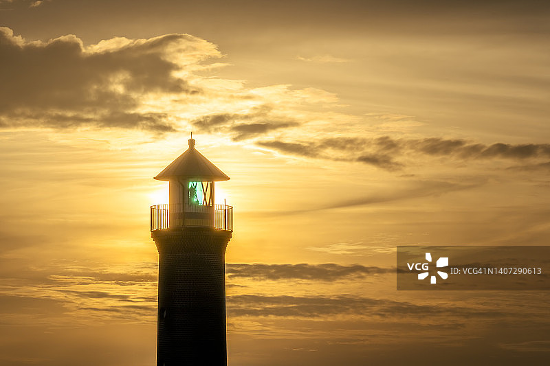 德国下萨克森州于斯特岛：梅默特菲尔灯塔与日落图片素材