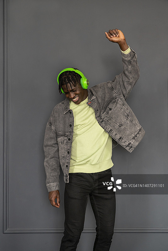 快乐的男人在墙前跳舞图片素材