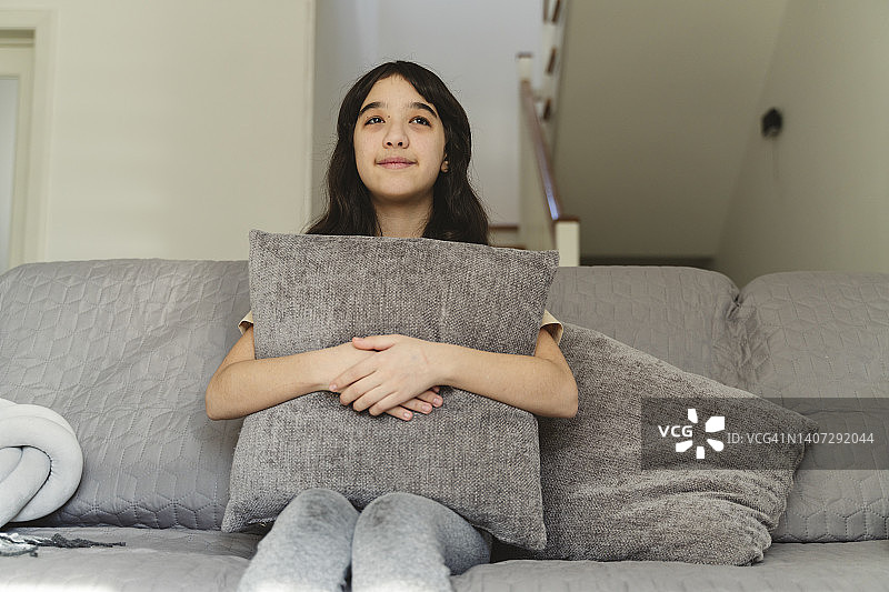 坐在沙发上做白日梦的女孩图片素材