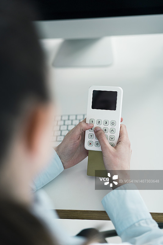 女商人于办公室输入信用卡密码图片素材