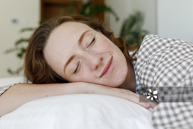 笑容满面的女人在卧室的枕头上放松图片素材