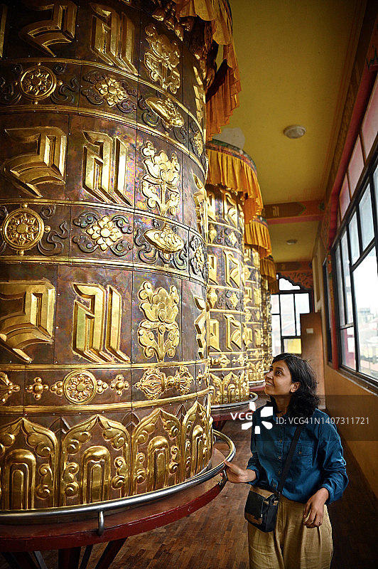 一位女士在转动巨大的祈祷轮图片素材
