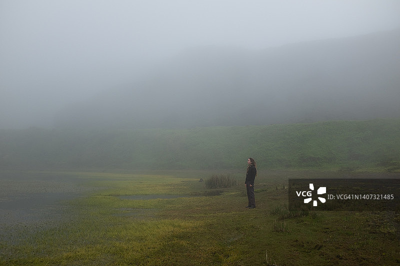 女人站在雾蒙蒙的风景中图片素材