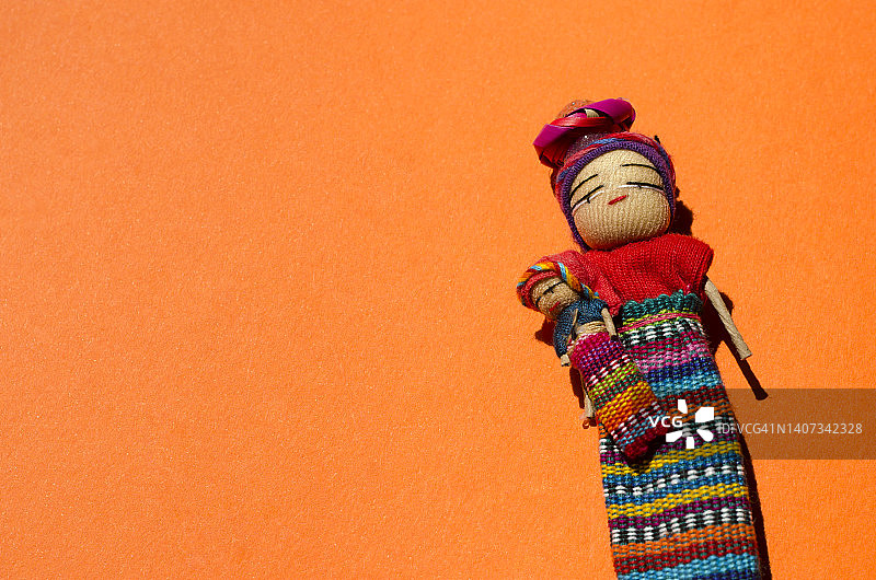 橙色背景下的忧虑娃娃图片素材