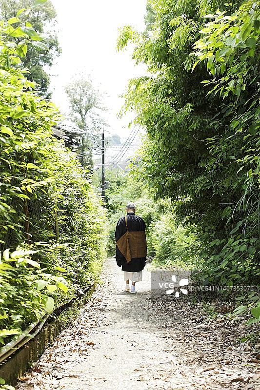穿着佛教僧侣披肩的佛教僧侣背影图片素材