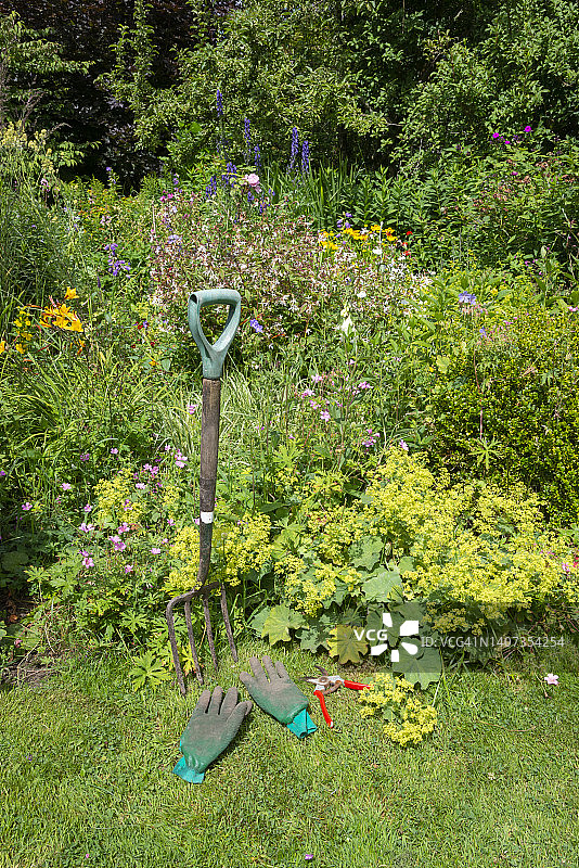英式乡村花园混合花境旁的园林工具图片素材